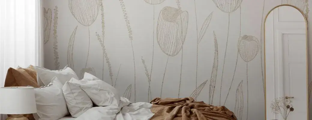 Beige tulip wall mural in a cosy bedroom A modern bedroom with a bed made up with white bed linen and a beige blanket. The wall is adorned with a subtle wall mural featuring a minimalist linear pattern of tulips in shades of beige and gold.